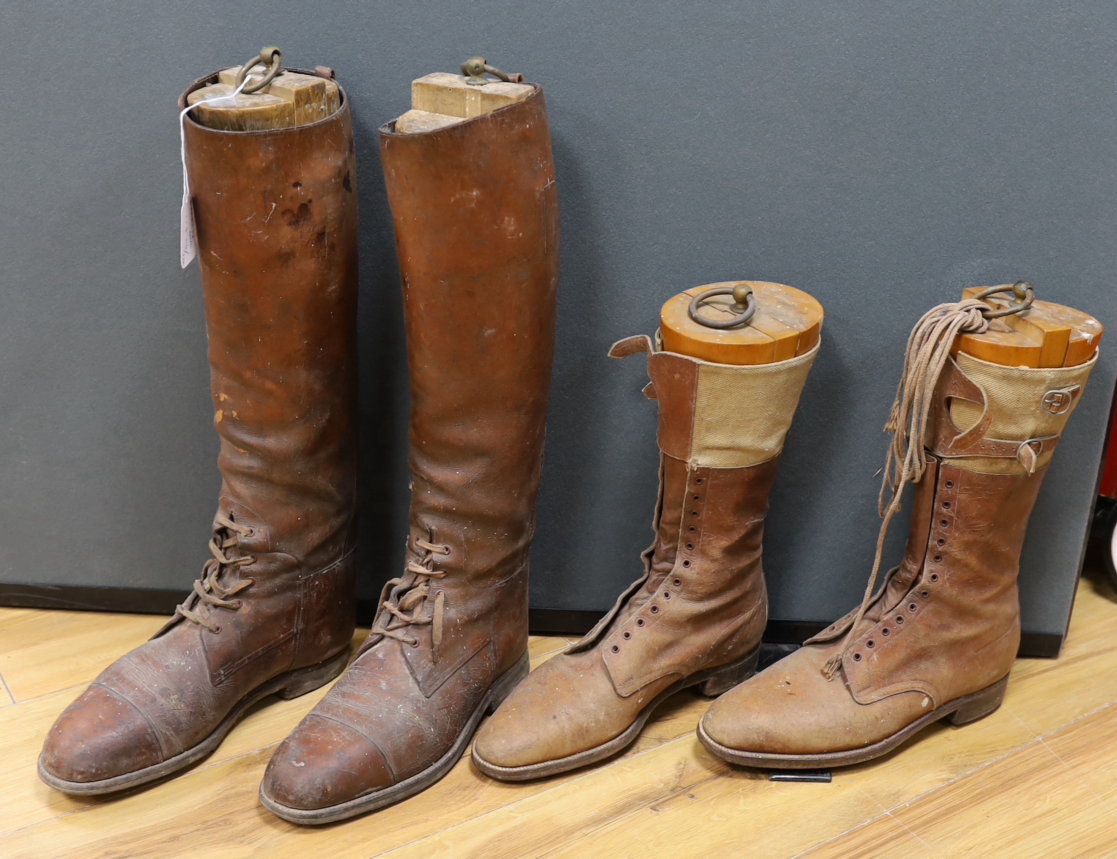 A pair of gentlemen’s brown leather laced riding boots together with a shorter pair of tan leather and canvas laced boots, both boots with wooden trees, tallest 51cm high